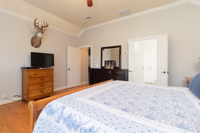 bedroom featuring visible vents, a ceiling fan, lofted ceiling, wood finished floors, and crown molding