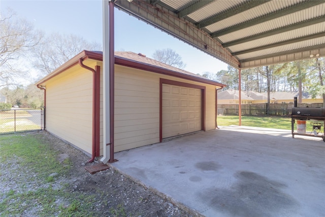 detached garage with concrete driveway and fence