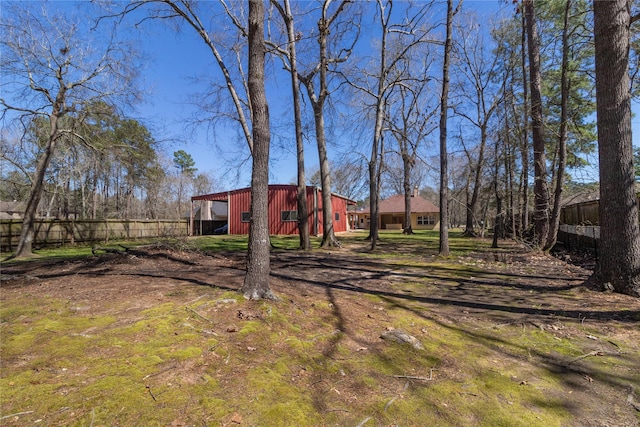 view of yard featuring an outbuilding, an outdoor structure, and fence