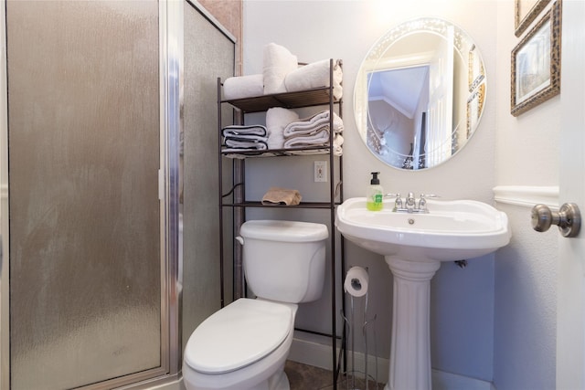 bathroom with toilet, a stall shower, and baseboards