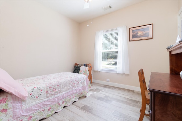 bedroom featuring light wood-style floors, visible vents, and baseboards