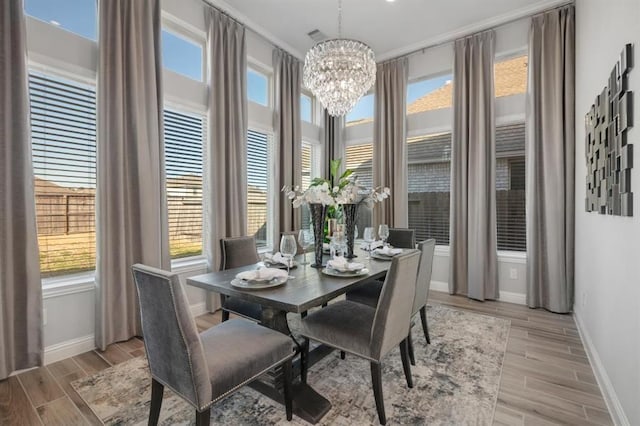 dining room featuring an inviting chandelier, baseboards, and wood finish floors