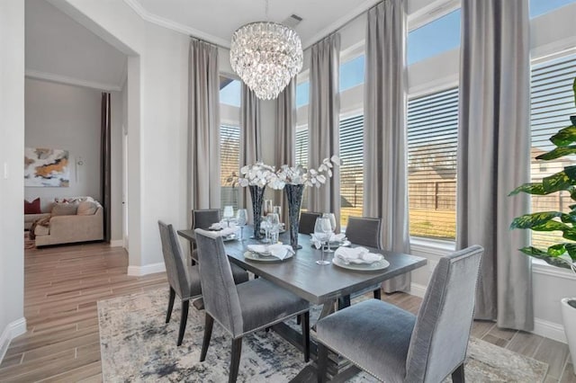 dining room featuring an inviting chandelier, plenty of natural light, baseboards, and wood finish floors