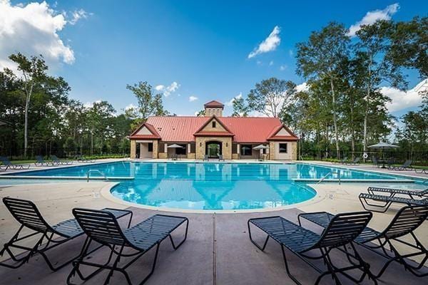 community pool with a patio and fence