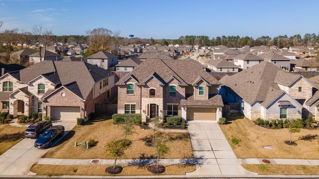 view of front of property featuring a residential view, brick siding, driveway, and fence