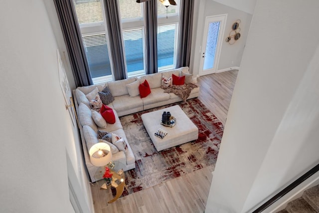 living room featuring wood finished floors, a ceiling fan, and baseboards