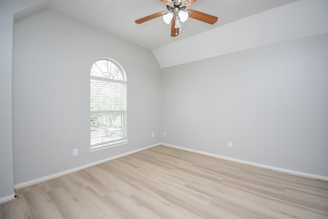 unfurnished room with lofted ceiling, light wood finished floors, ceiling fan, and baseboards