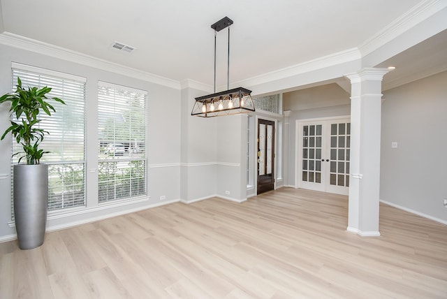 unfurnished dining area with ornate columns, light wood-style flooring, and ornamental molding