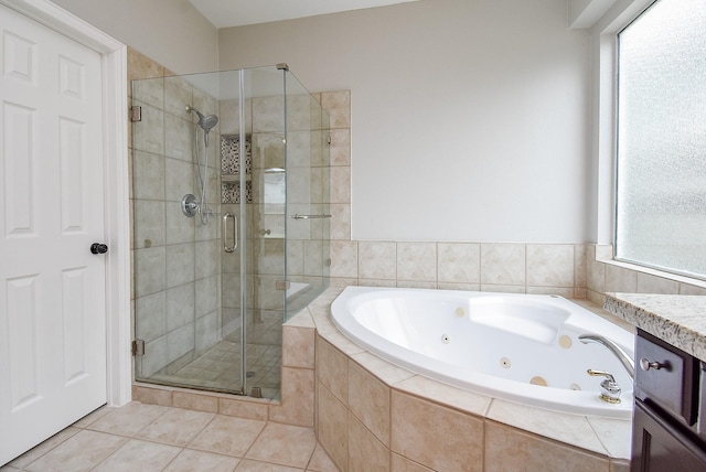 bathroom featuring a tub with jets, a stall shower, vanity, and tile patterned floors