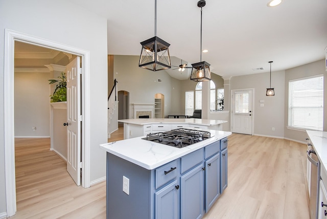 kitchen featuring black gas cooktop, blue cabinets, light wood finished floors, and a center island