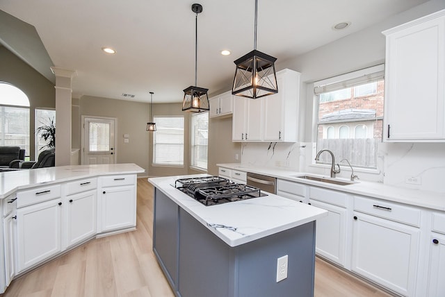 kitchen with light wood-type flooring, dishwasher, a sink, and black gas stovetop