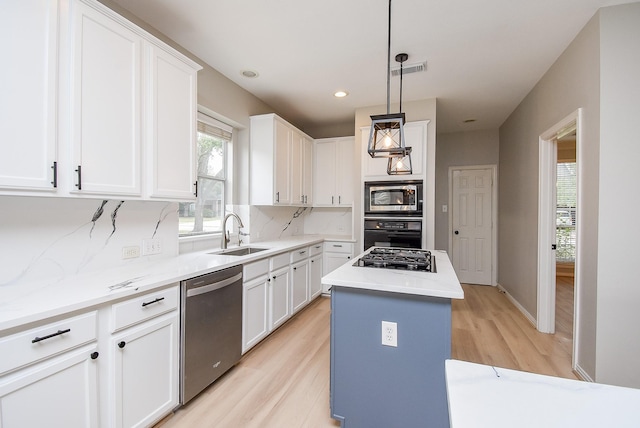 kitchen featuring visible vents, a center island, a sink, black appliances, and backsplash