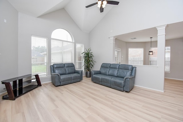 living area featuring high vaulted ceiling, wood finished floors, a ceiling fan, and ornate columns