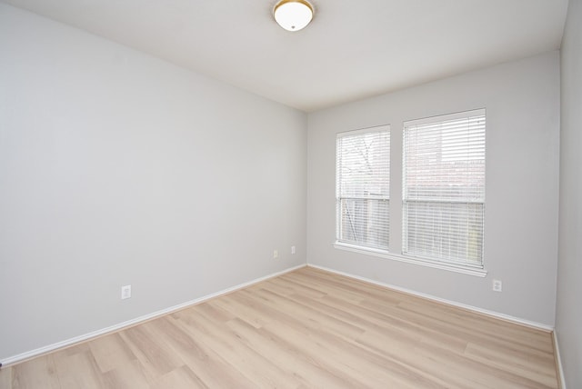 spare room with light wood-style floors and baseboards