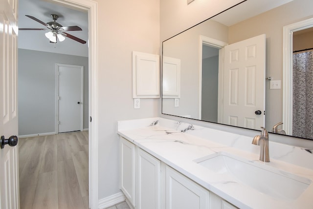 full bath featuring baseboards, wood finished floors, a ceiling fan, and vanity