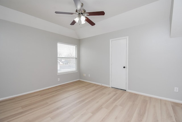 spare room with a ceiling fan, lofted ceiling, baseboards, and light wood finished floors