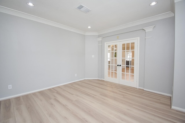 empty room with light wood finished floors, french doors, visible vents, and crown molding