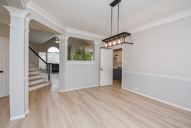 empty room featuring light wood-style floors, decorative columns, stairs, and ornamental molding