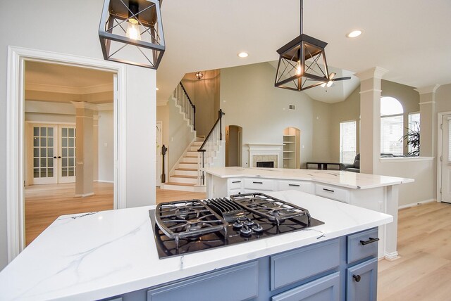 kitchen with blue cabinetry, recessed lighting, black gas stovetop, light wood-type flooring, and ornate columns