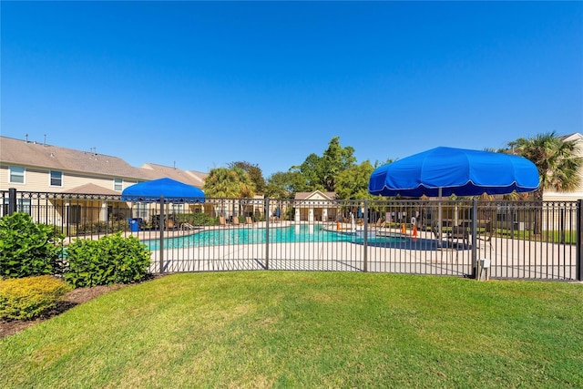 community pool featuring a yard, fence, and a patio