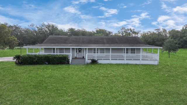 farmhouse-style home featuring roof with shingles, a porch, and a front lawn