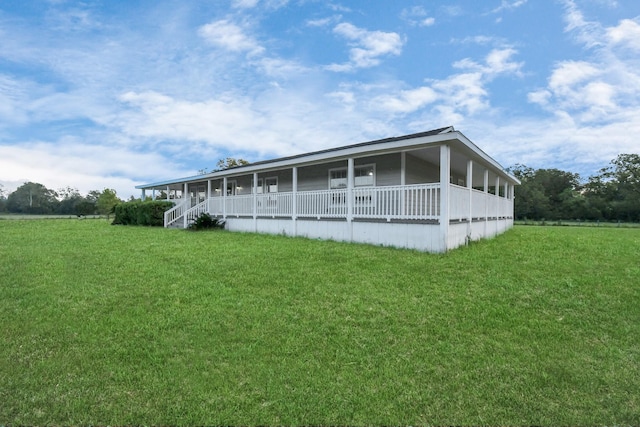 rear view of property with a sunroom and a yard