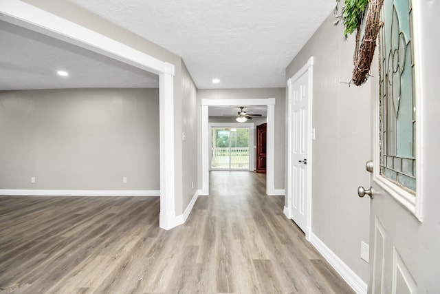 foyer with a textured ceiling, recessed lighting, wood finished floors, and baseboards