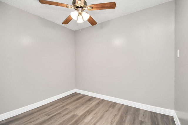 unfurnished room with wood finished floors, a ceiling fan, and baseboards