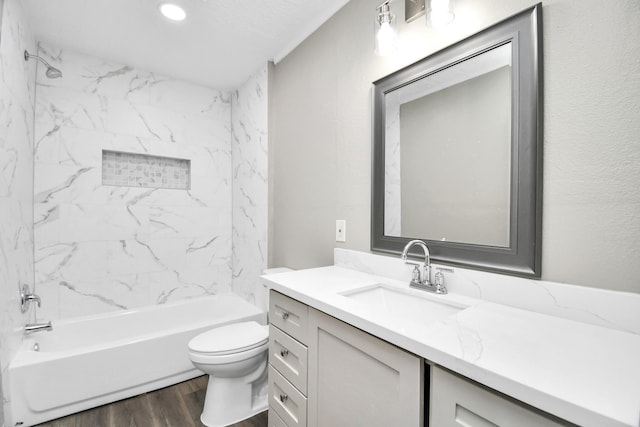 full bathroom featuring washtub / shower combination, vanity, wood finished floors, and toilet