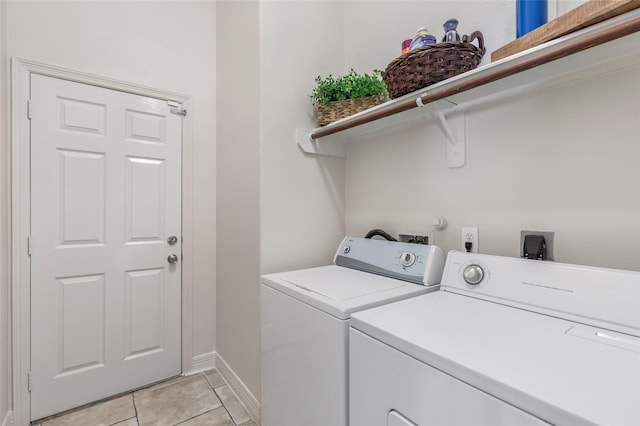 washroom featuring laundry area, light tile patterned flooring, washer and clothes dryer, and baseboards