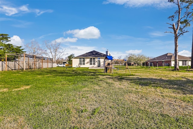 view of yard featuring a playground and fence