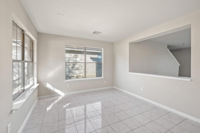 empty room with baseboards and visible vents