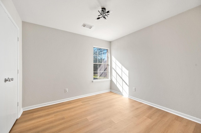 unfurnished room with light wood-type flooring, baseboards, and visible vents