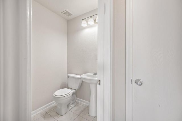 bathroom featuring visible vents, toilet, a sink, tile patterned flooring, and baseboards