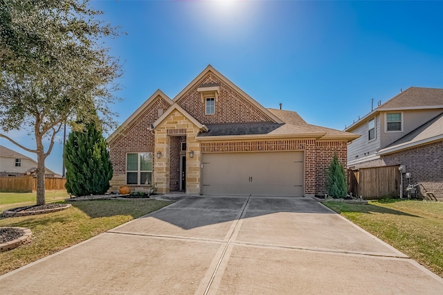 traditional-style home with an attached garage, brick siding, fence, driveway, and a front lawn