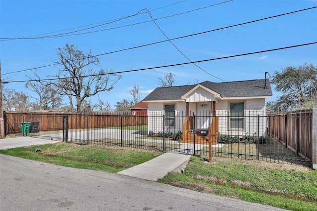 bungalow featuring roof with shingles, a fenced front yard, and a gate