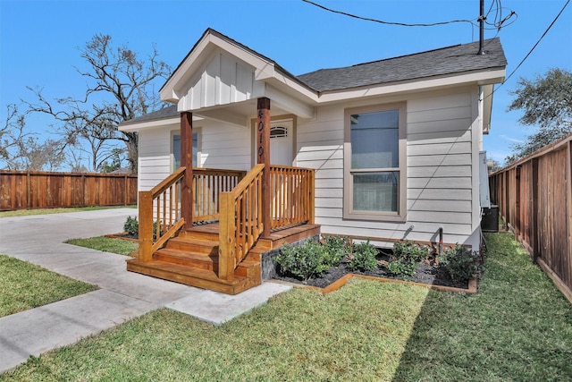 bungalow-style home featuring fence and a front lawn