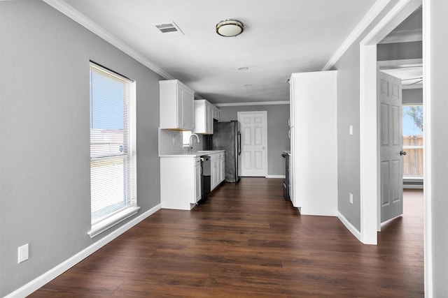 kitchen featuring dark wood-style flooring, light countertops, visible vents, freestanding refrigerator, and dishwasher