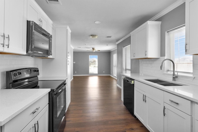 kitchen with black appliances, a sink, white cabinetry, and crown molding