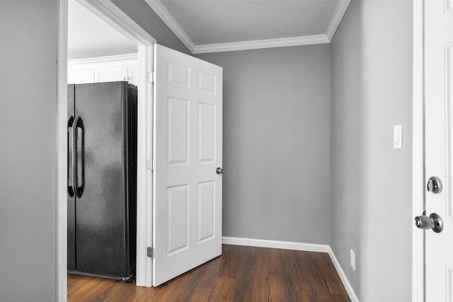 kitchen featuring crown molding, dark wood-type flooring, freestanding refrigerator, and white cabinetry