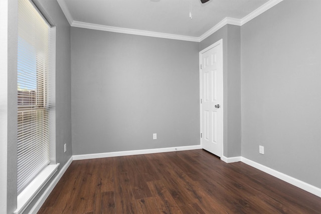 unfurnished room with crown molding, baseboards, and wood finished floors