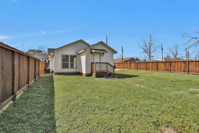 back of property featuring a fenced backyard, a lawn, and central air condition unit