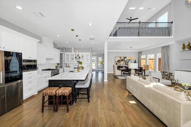 kitchen with stainless steel appliances, dark wood-type flooring, a sink, visible vents, and white cabinetry