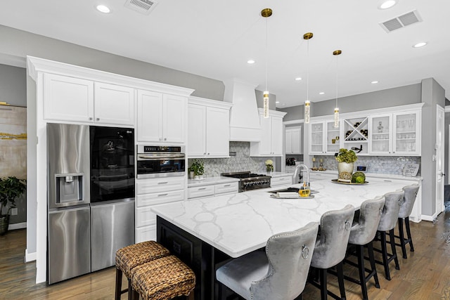 kitchen with stainless steel appliances, visible vents, a sink, and white cabinetry