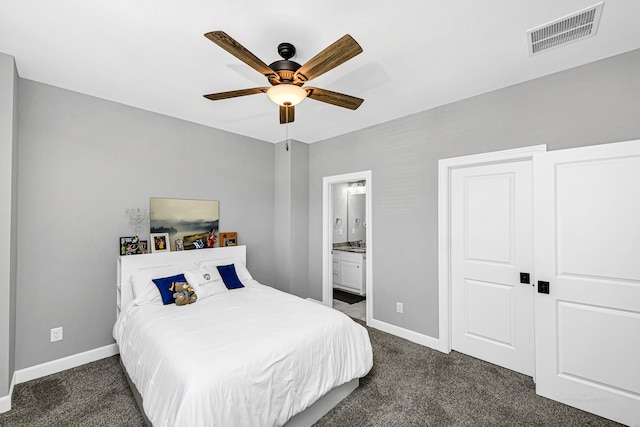 bedroom featuring dark colored carpet, visible vents, baseboards, and ensuite bathroom