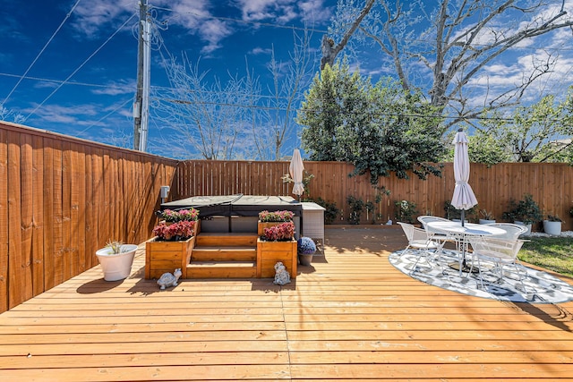 deck with outdoor dining area and a fenced backyard