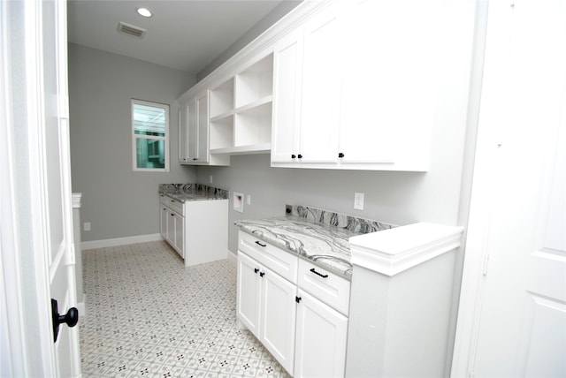 washroom with hookup for a washing machine, visible vents, baseboards, cabinet space, and light floors