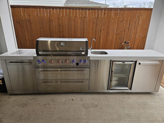 view of patio / terrace featuring an outdoor kitchen, a sink, and a grill