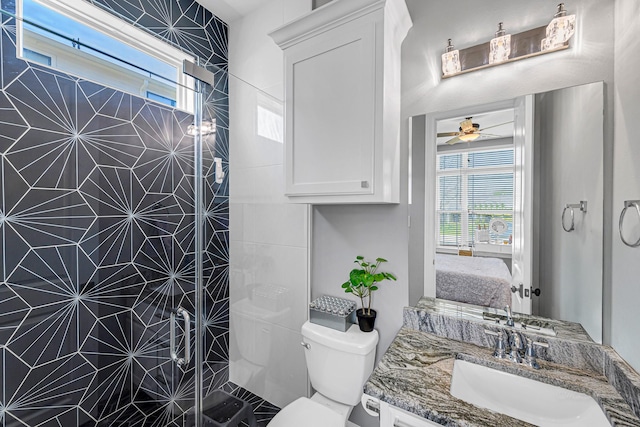 bathroom featuring connected bathroom, toilet, a ceiling fan, vanity, and tiled shower