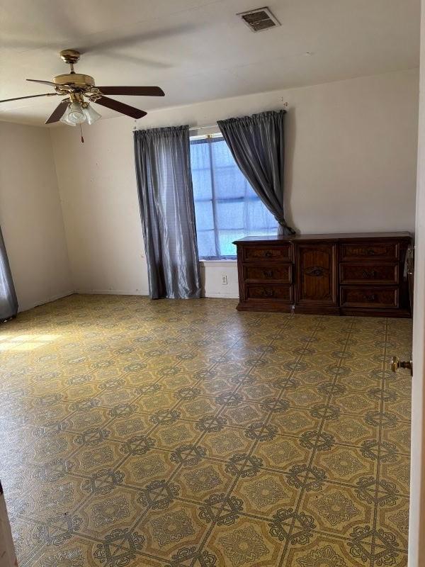 spare room featuring ceiling fan and visible vents